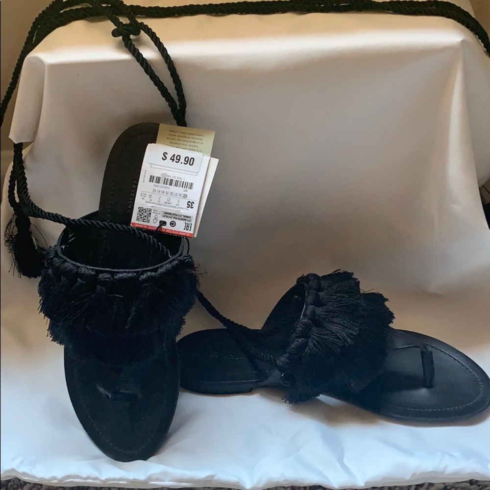 FLAT LEATHER SANDALS WITH TASSELS